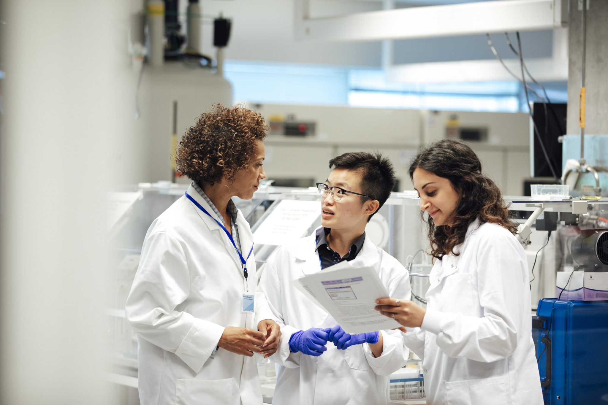 Three scientists in discussion in a lab