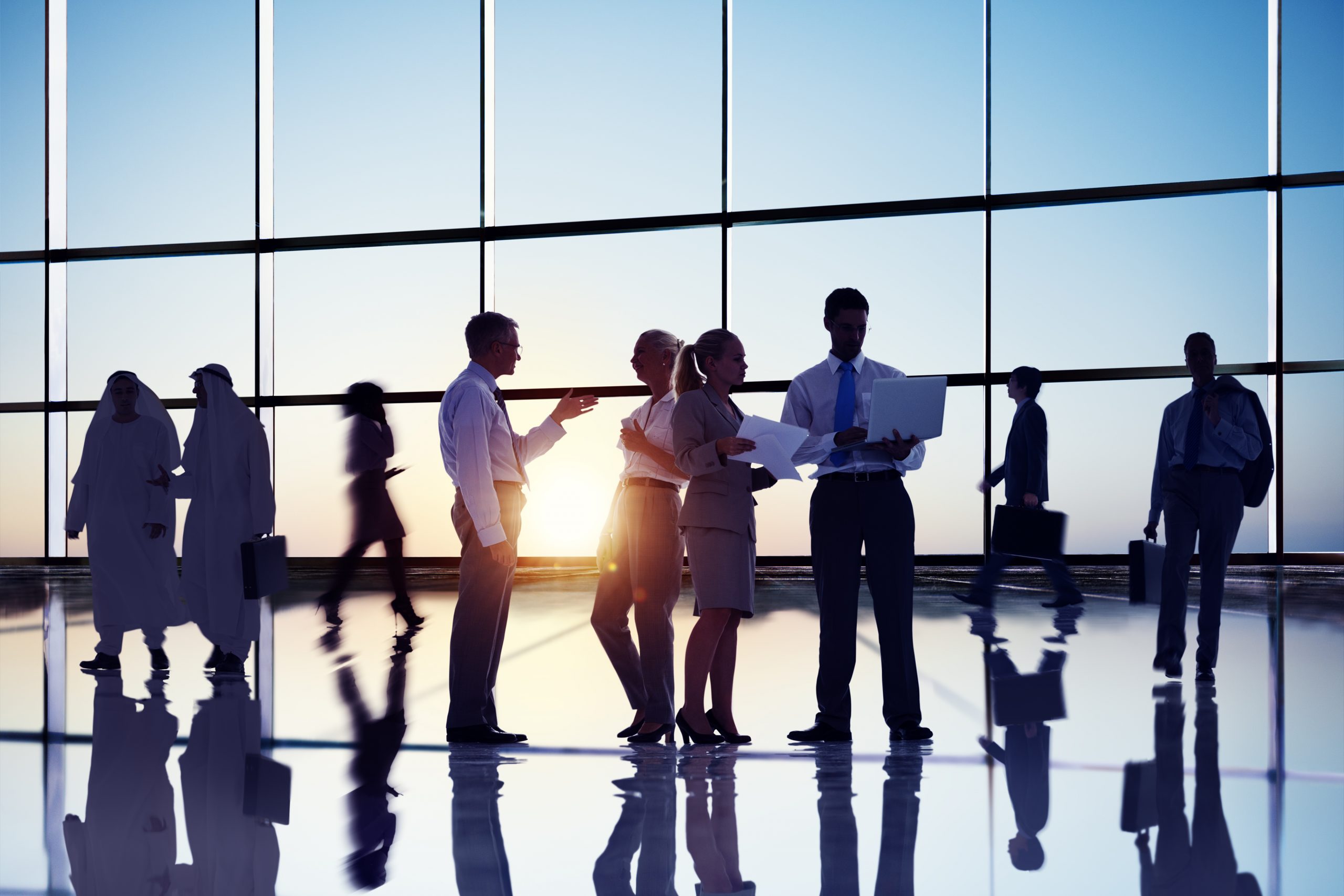 Business people passing in a bustling office lobby